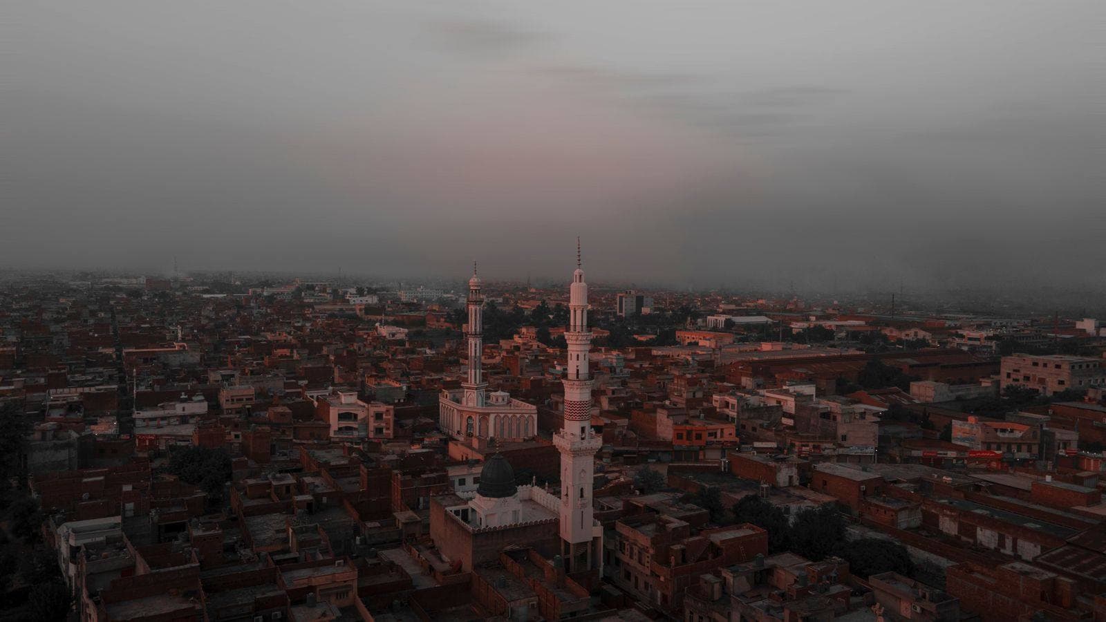 Aerial view of Gujranwala with mosque minarets at dusk