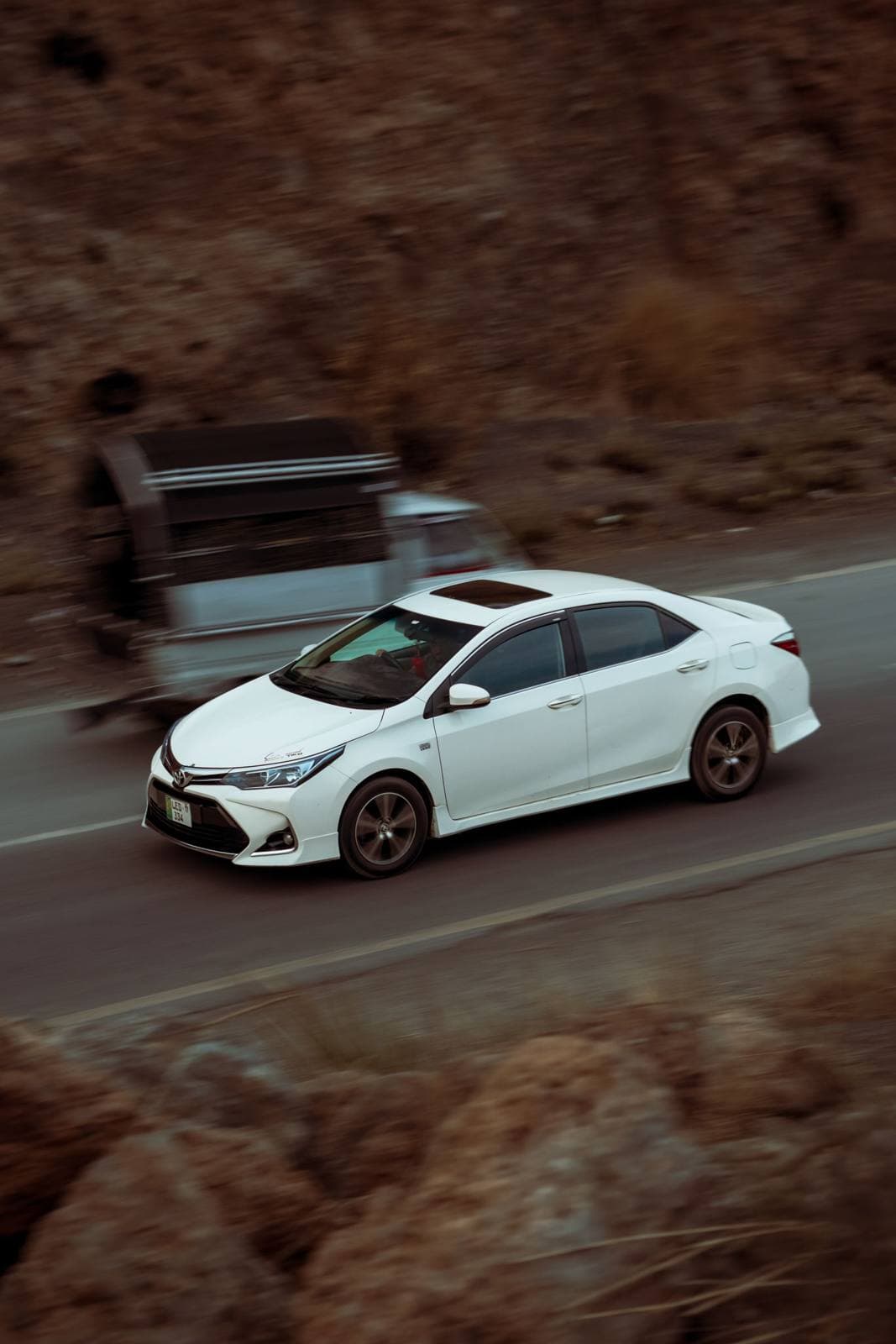 White Toyota Corolla on a mountain road in Kohat